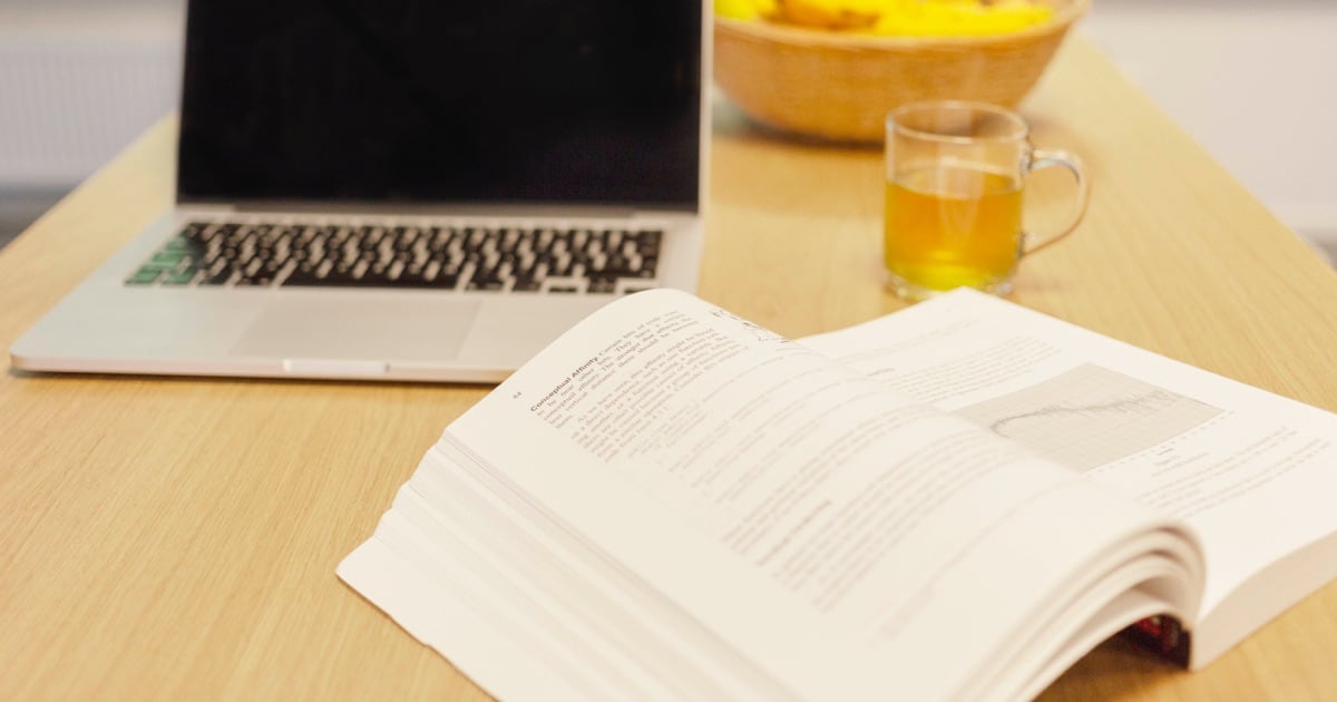 Een laptop en opengeslagen boek