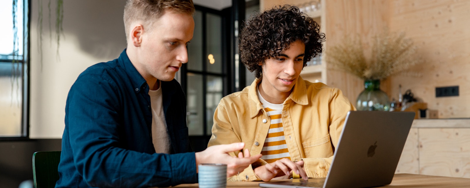 Twee personen werken achter een laptop