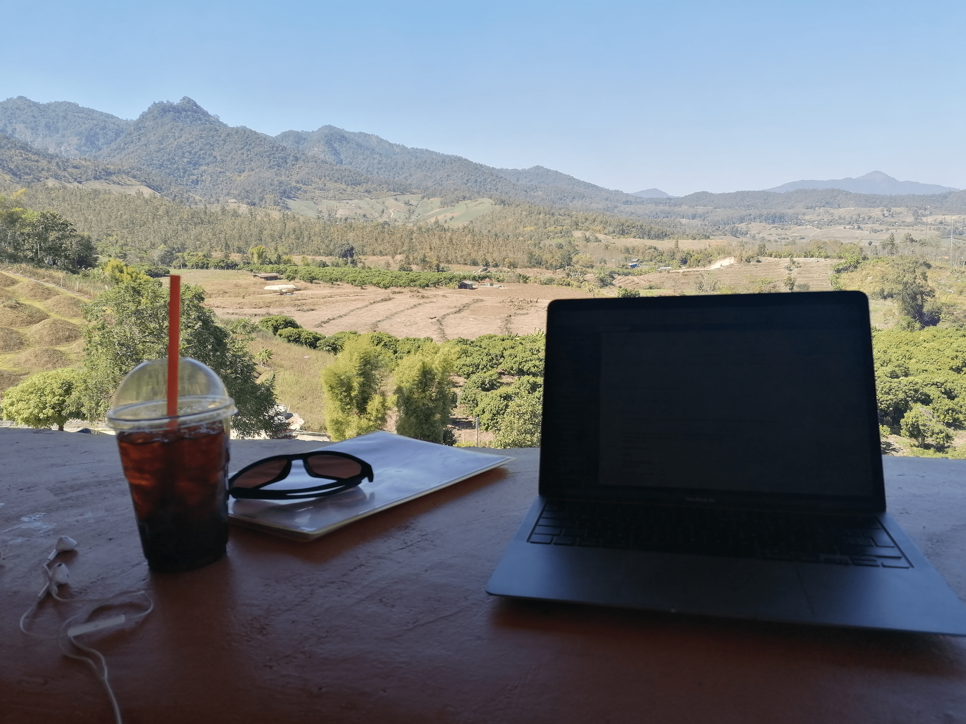 Boyke werkt achter zijn laptop met een mooi uitzicht