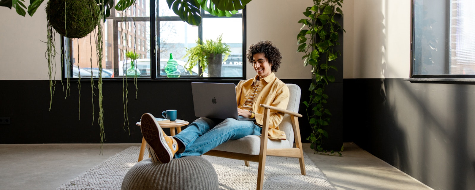 Ondernemer zit op de stoel met zijn laptop en een kop koffie