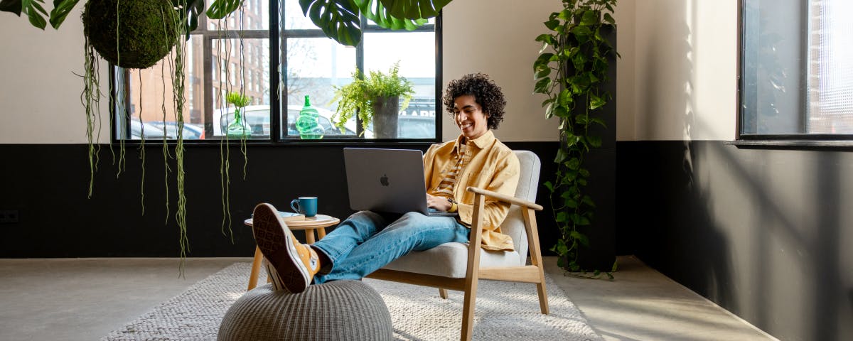 Ondernemer zit op de stoel met zijn laptop en een kop koffie