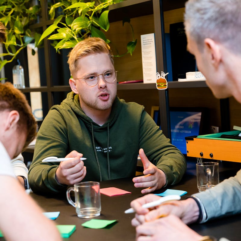 Sven en Gijs aan het brainstormen met post-it's tijdens een kennissessie in de kantine