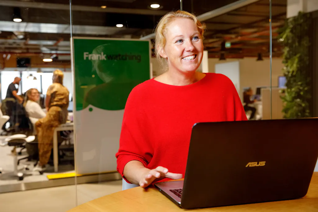 Marieke lachend achter haar laptop