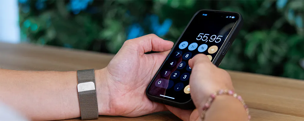 Handen die telefoon vasthouden en berekening maken met rekenmachine-app