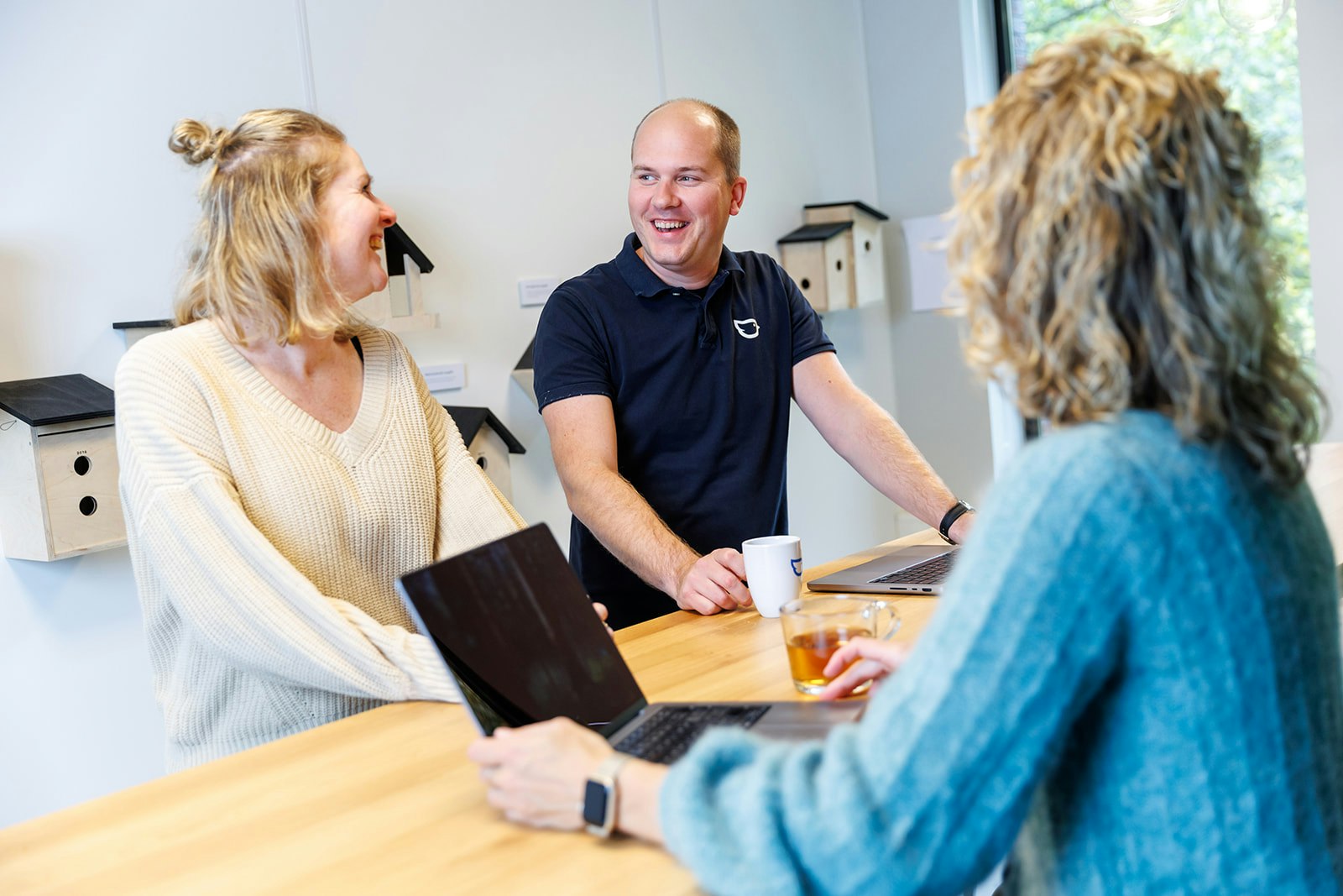 Drie collega's aan een statafel in gesprek