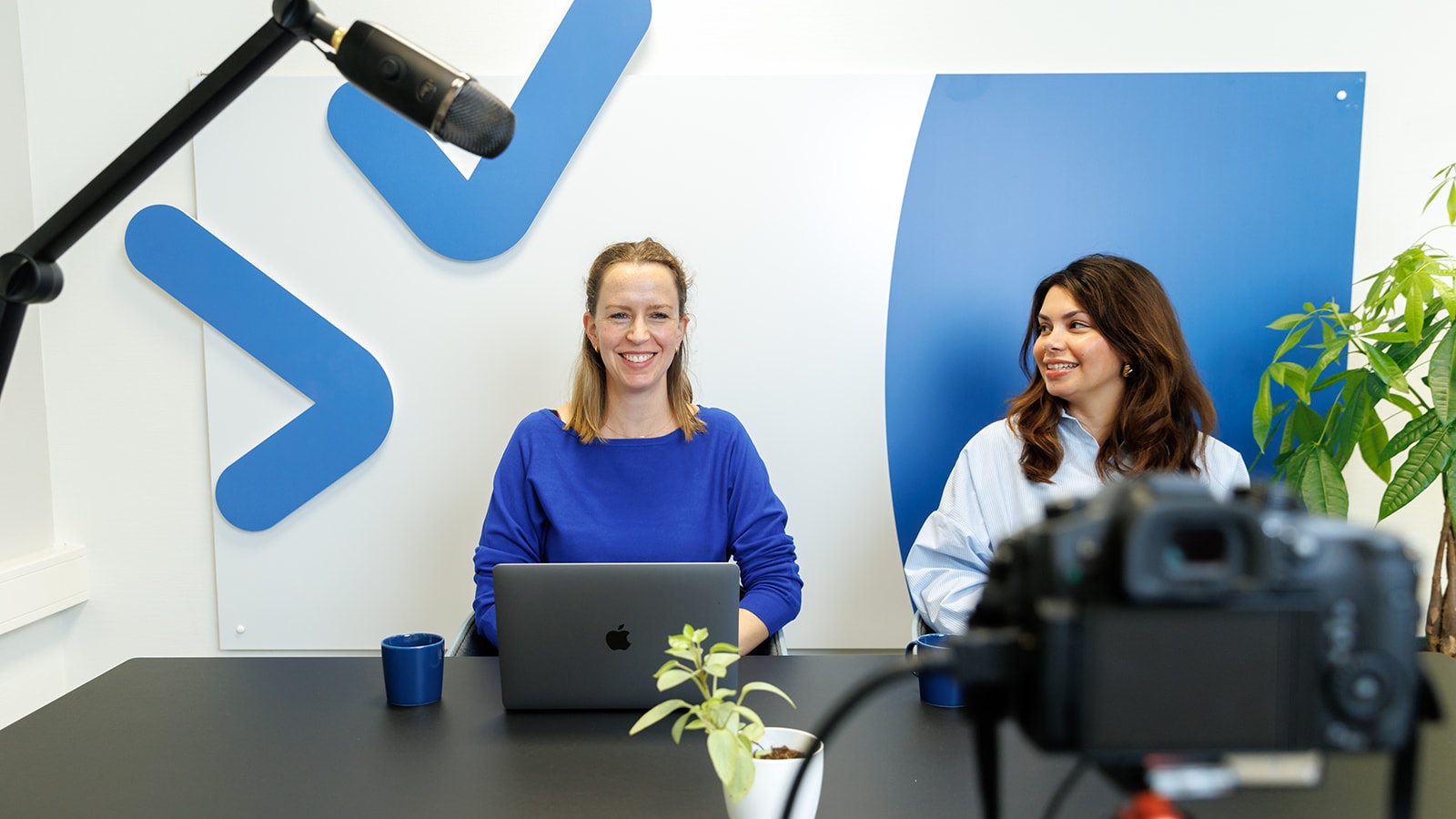 Liesbeth en Gladys tijdens livesessie achter bureau voor camera