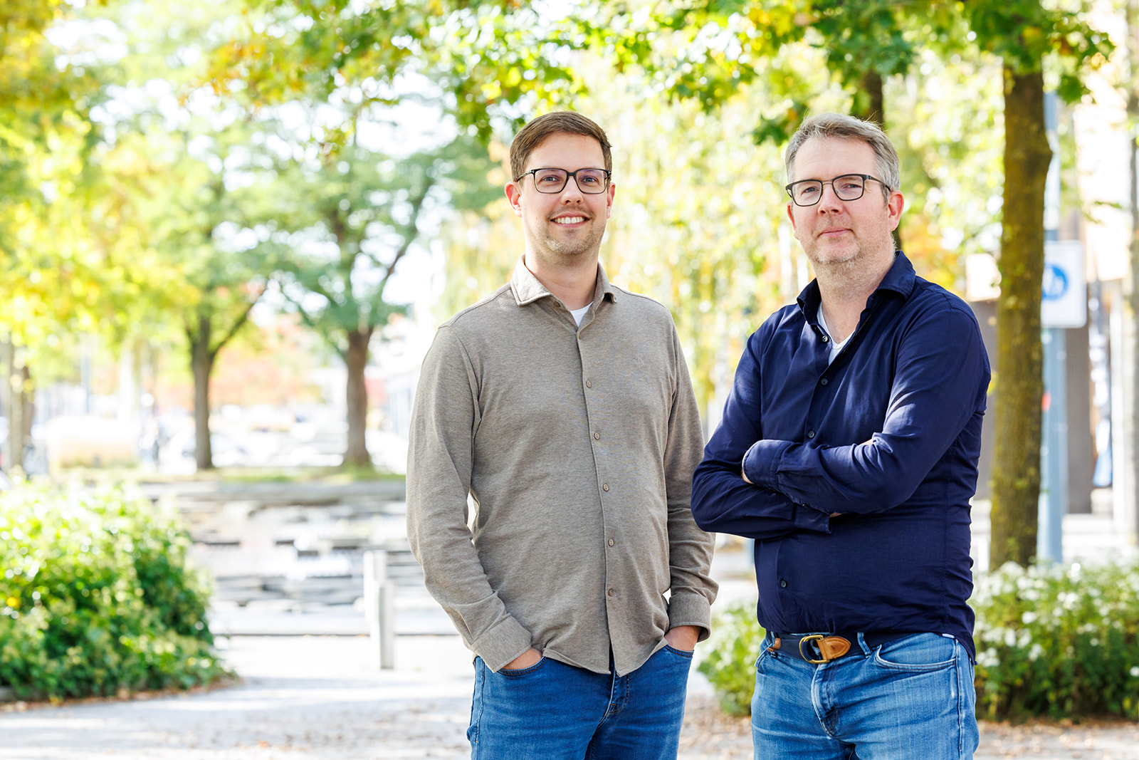 Joost en Edwin kijken naar de camera met groene bomen op de achtergrond