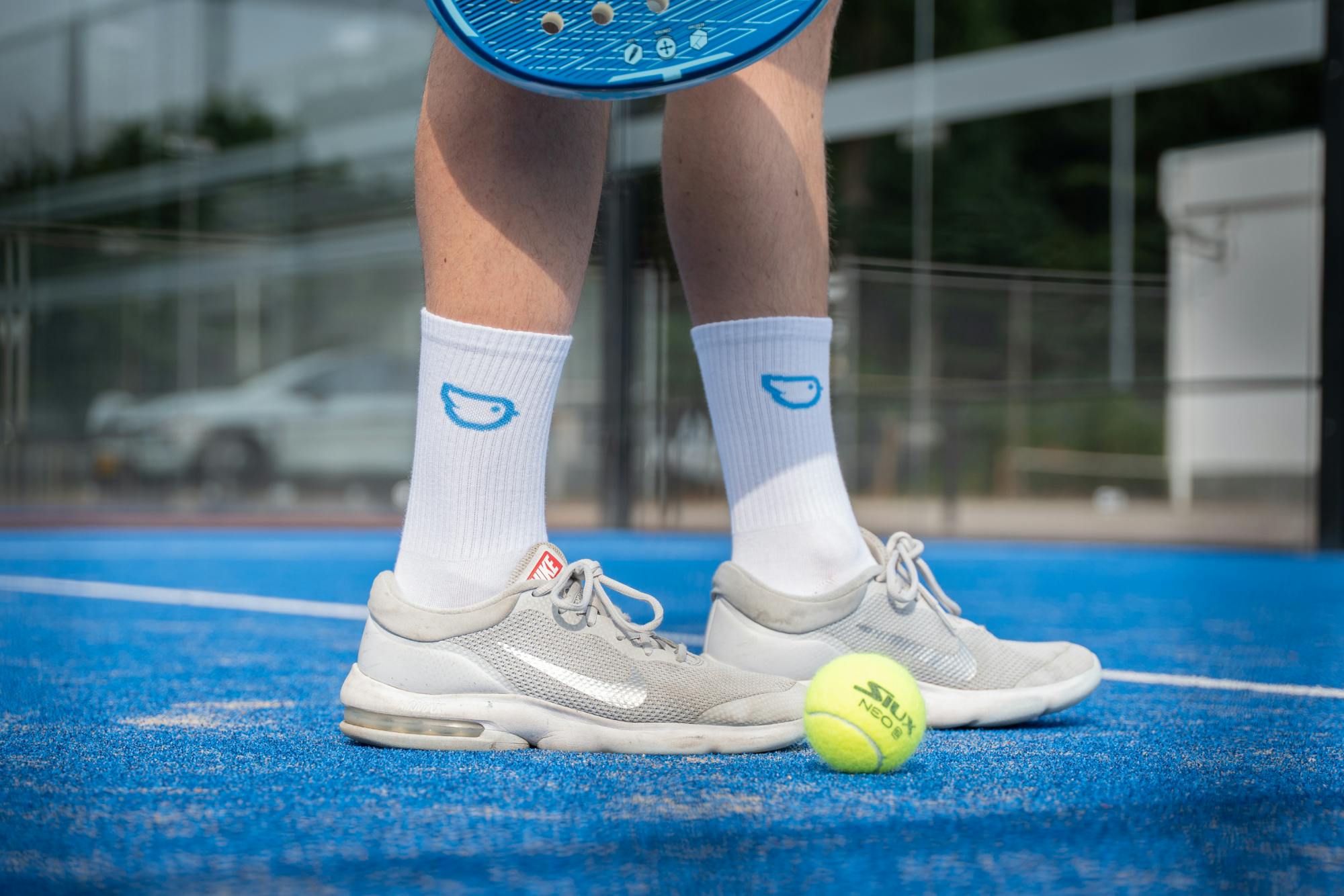 Collega met Moneybird sokken aan tijdens padellen met collega's