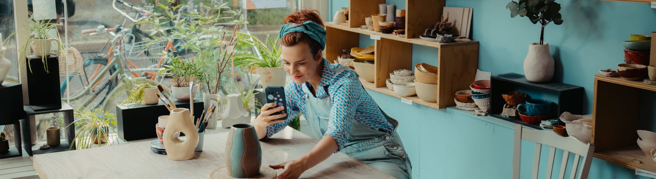 Merel maakt een foto van een vaas om te verkopen via online verkopen in Moneybird