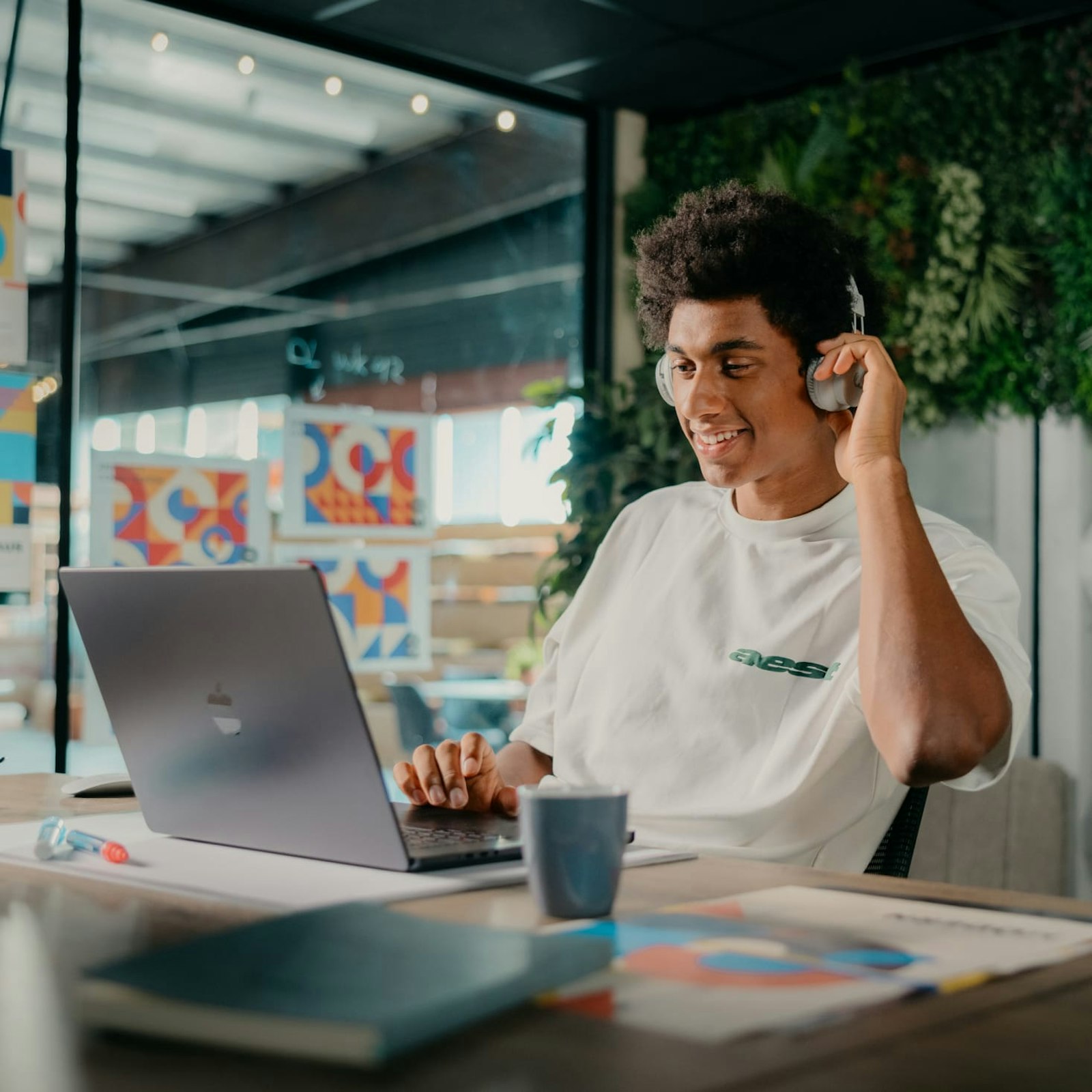 Matthieu zit achter zijn laptop met headphones