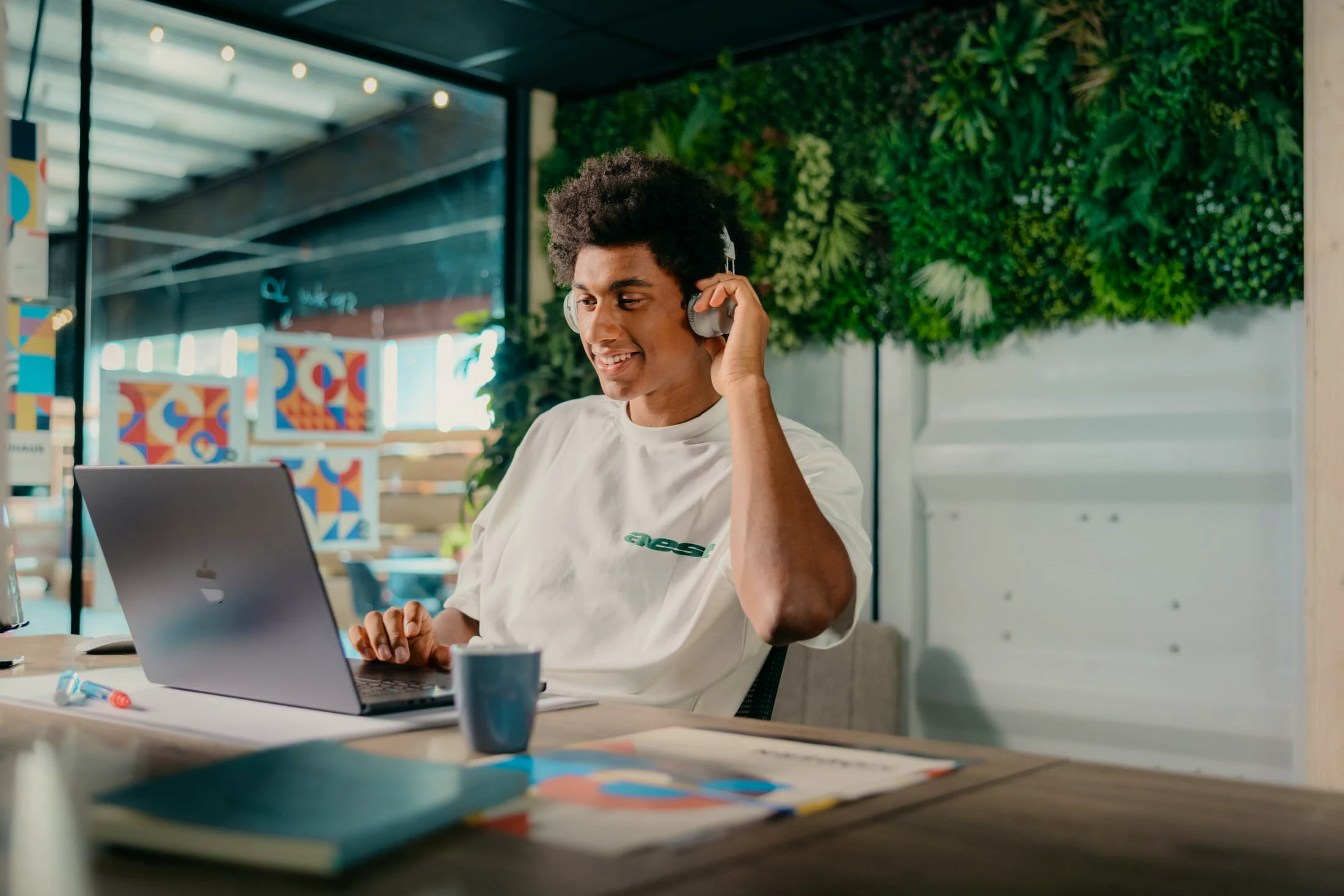 Matthieu zit achter zijn laptop met headphones