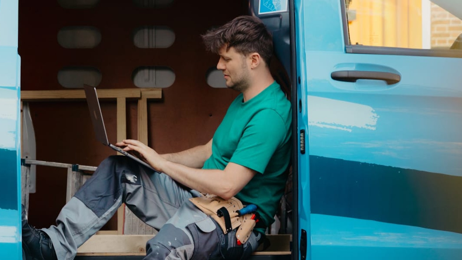 Arend met laptop in zijn werkbus met schuifdeur open