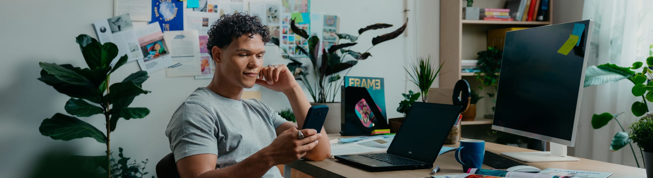 Mees met mobiel achter zijn bureau