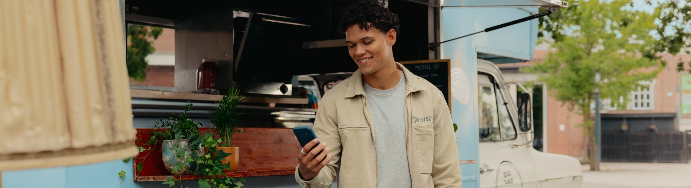 Mees kijkt op telefoon voor een foodtruck