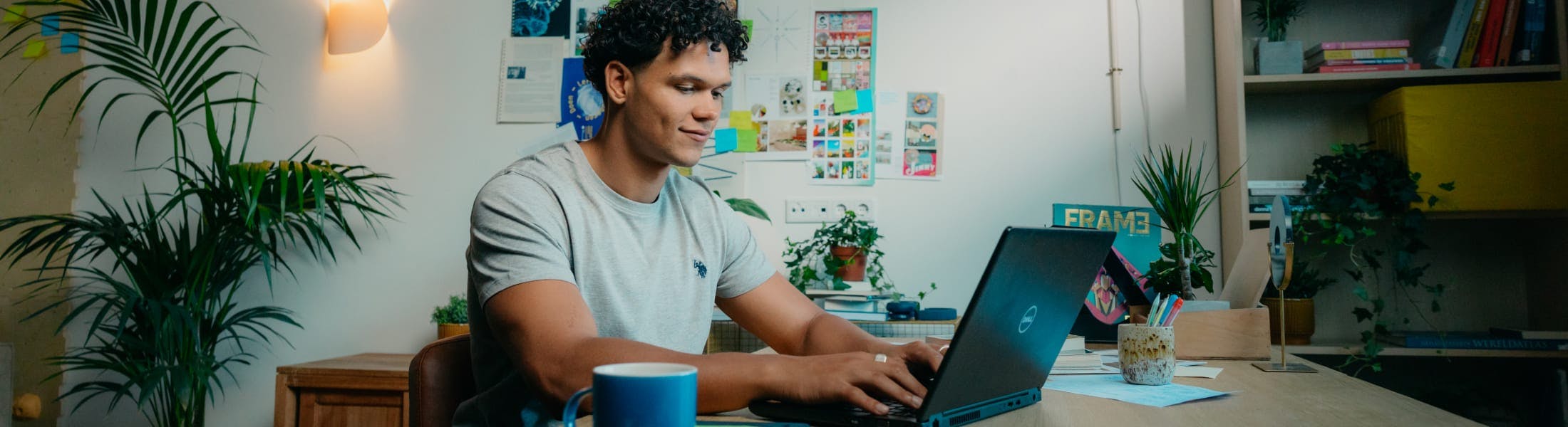 Mees met laptop achter zijn bureau