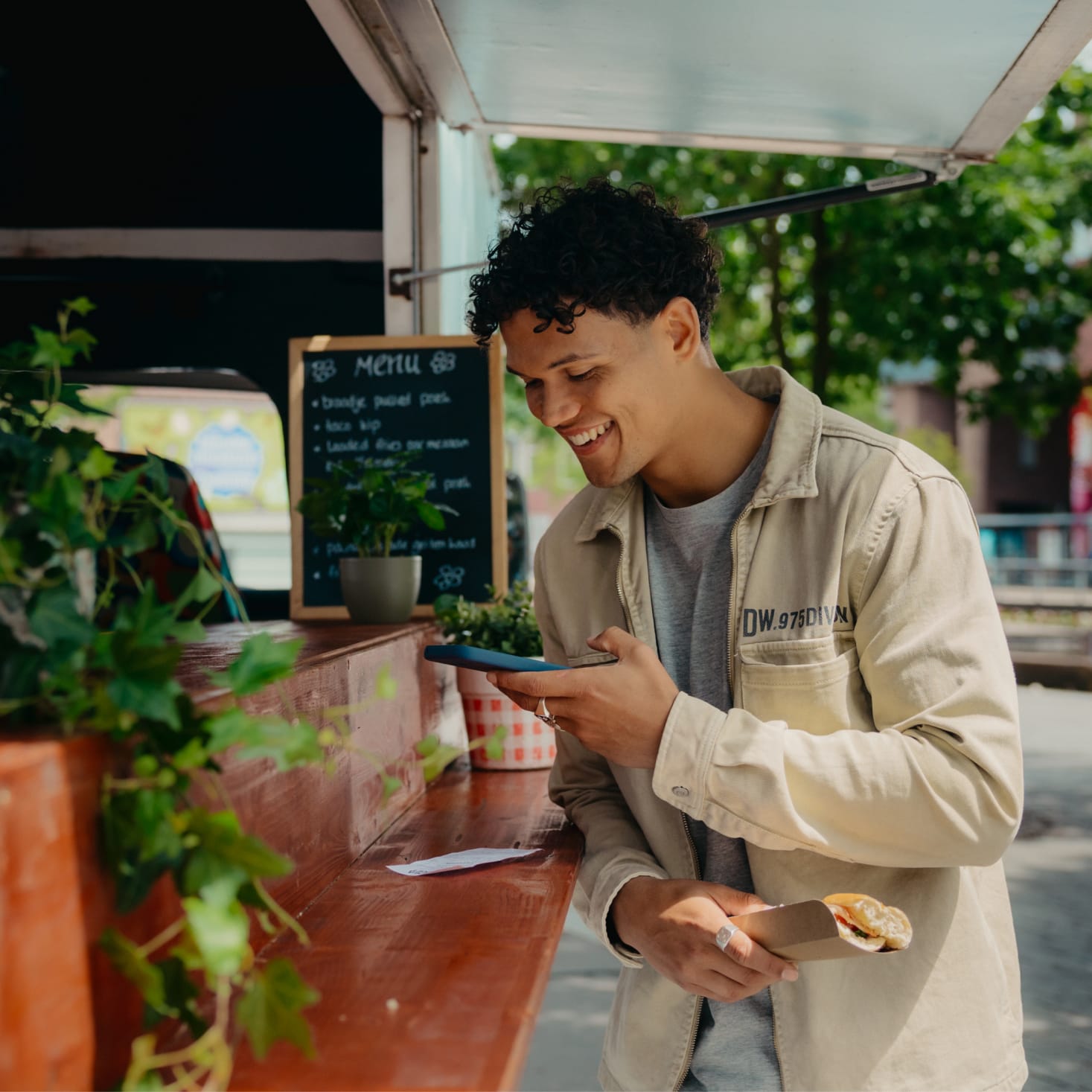 Mees maakt een foto van een bonnetje bij een foodtruck