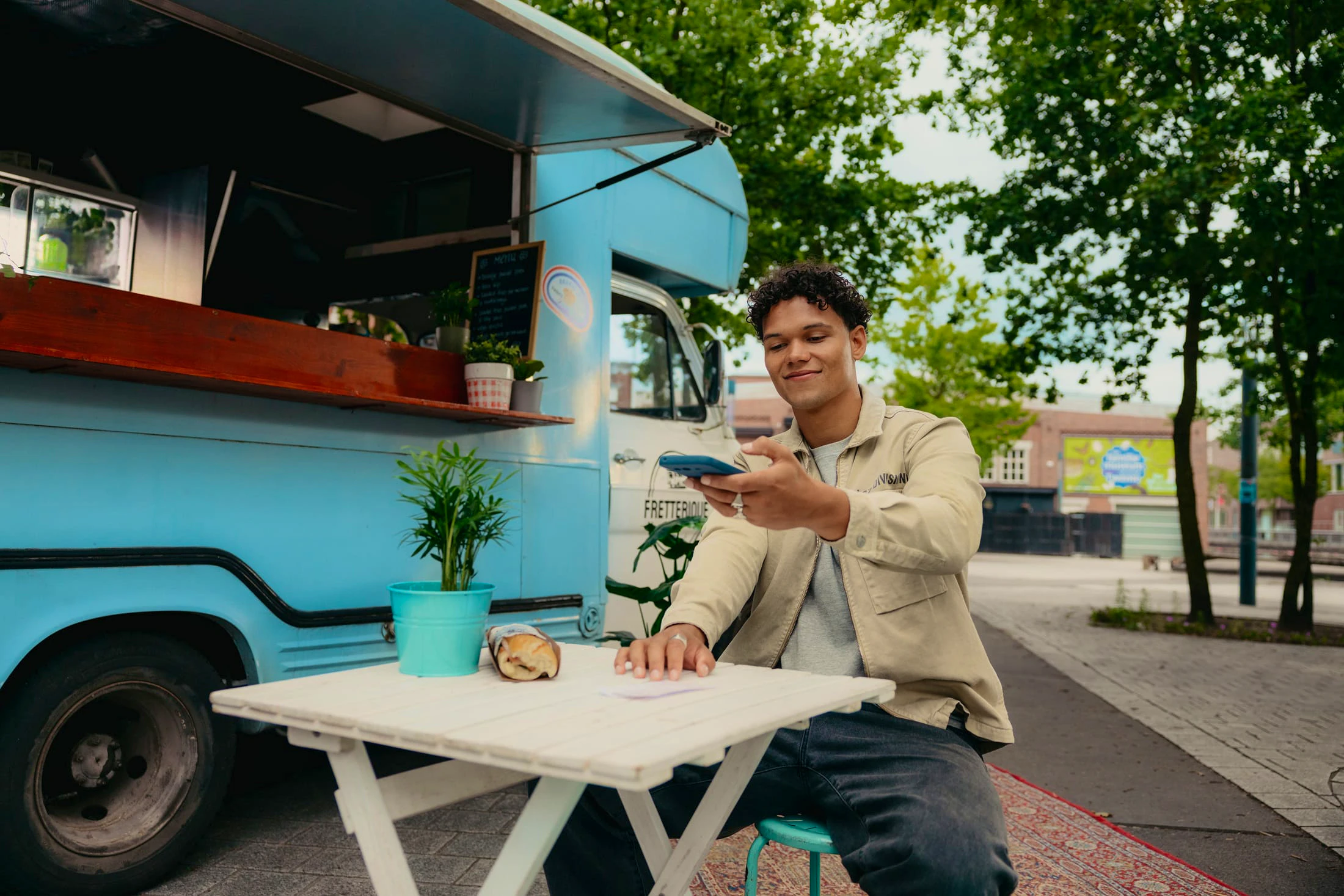 Mees maakt een foto van een bonnetje bij een foodtruck