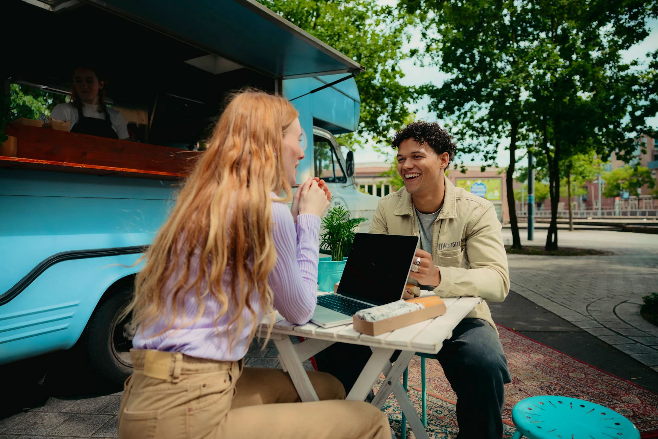 Zakelijke lunch van Mees met een klant voor een foodtruck met laptop op tafel