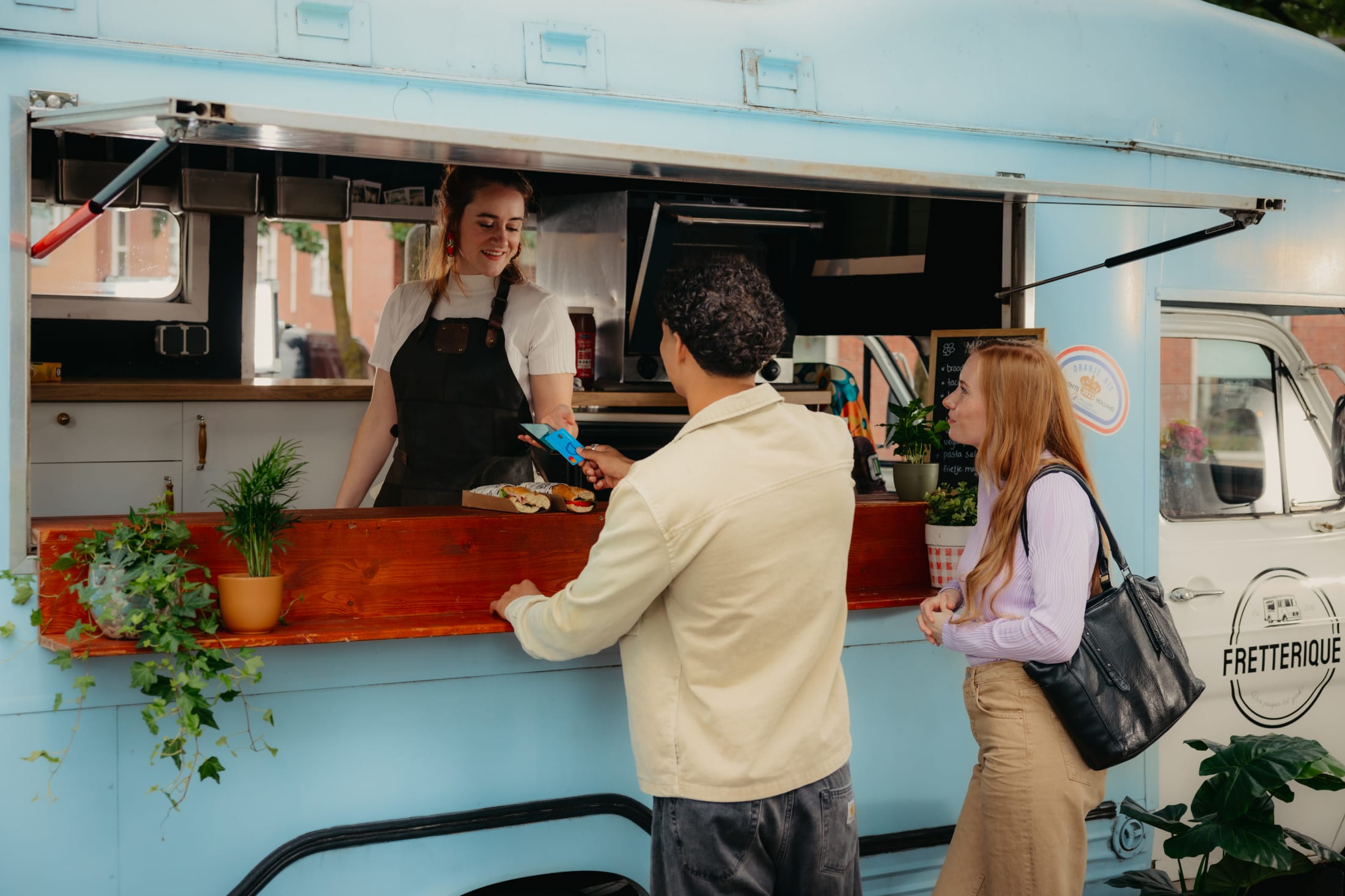 Mees betaald bij een foodtruck met zijn Moneybird bankpas