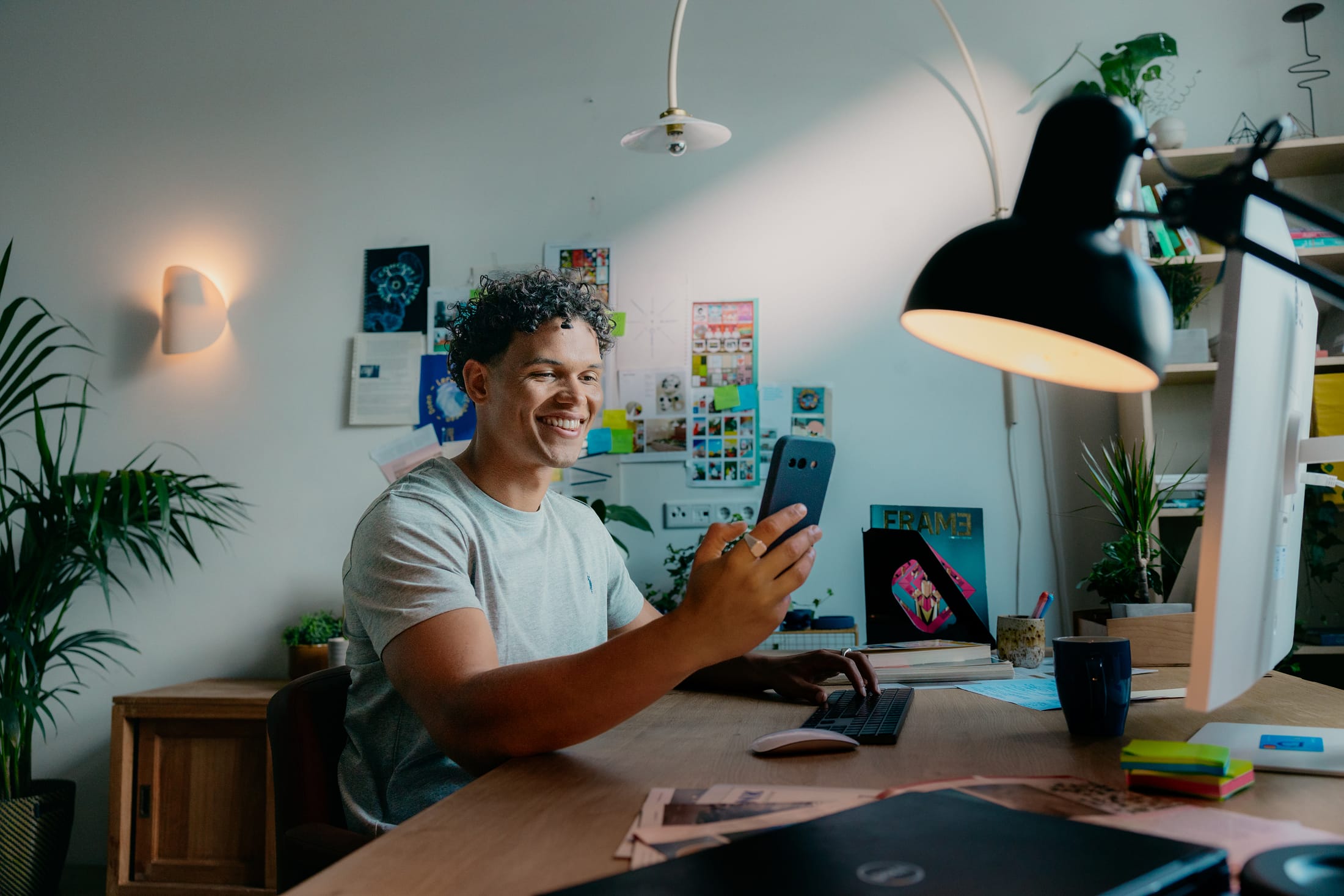Mees met telefoon achter zijn bureau