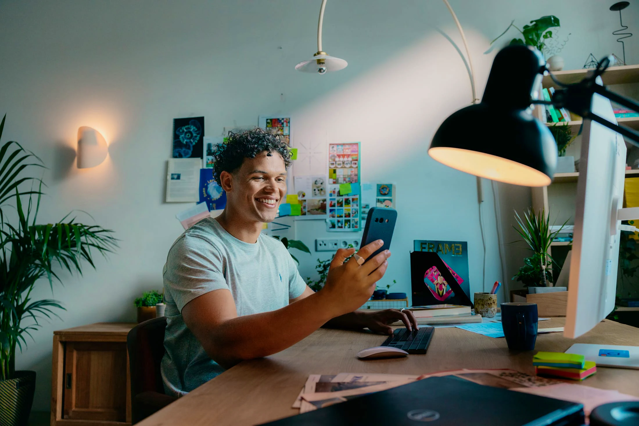 Mees met telefoon achter zijn bureau