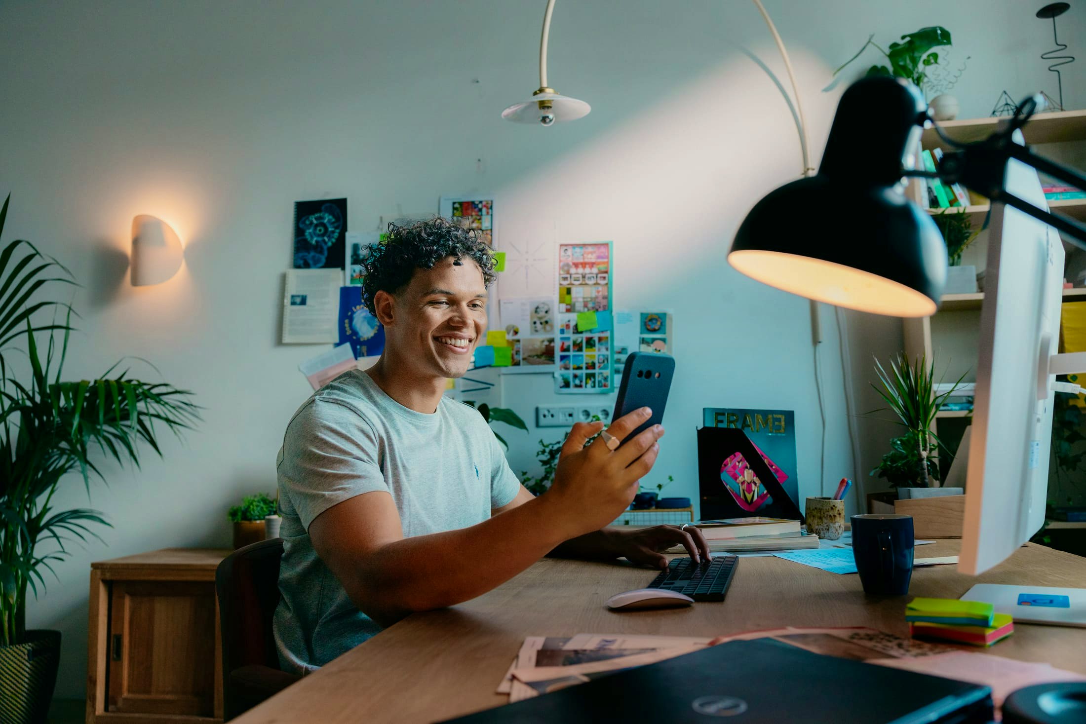 Mees met telefoon achter zijn bureau