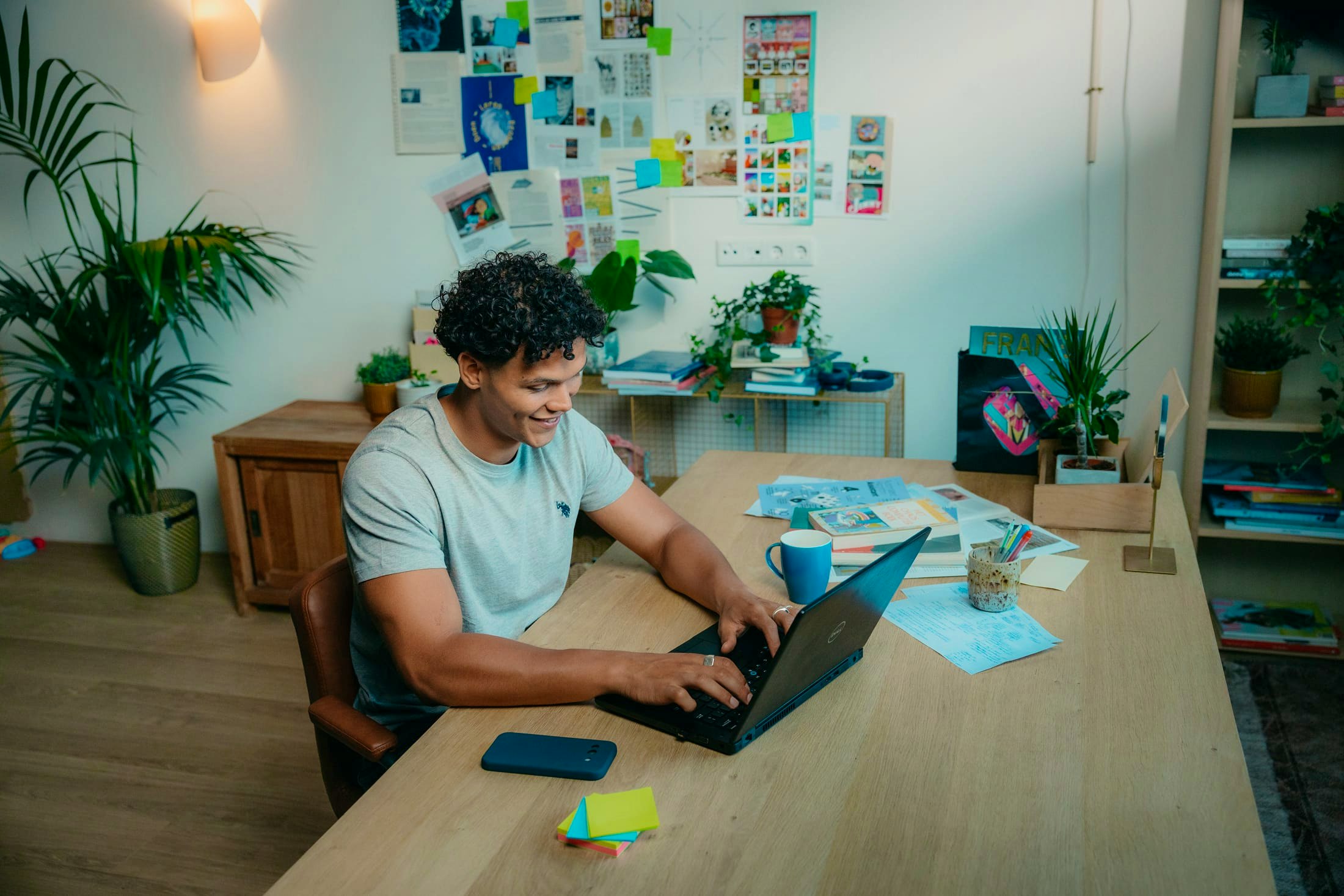 Mees met laptop achter zijn bureau