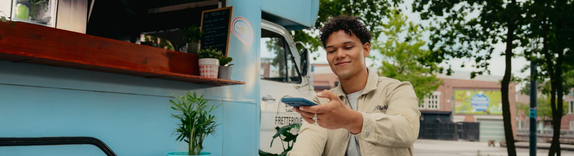 Mees maakt een foto van een bonnetje bij een foodtruck