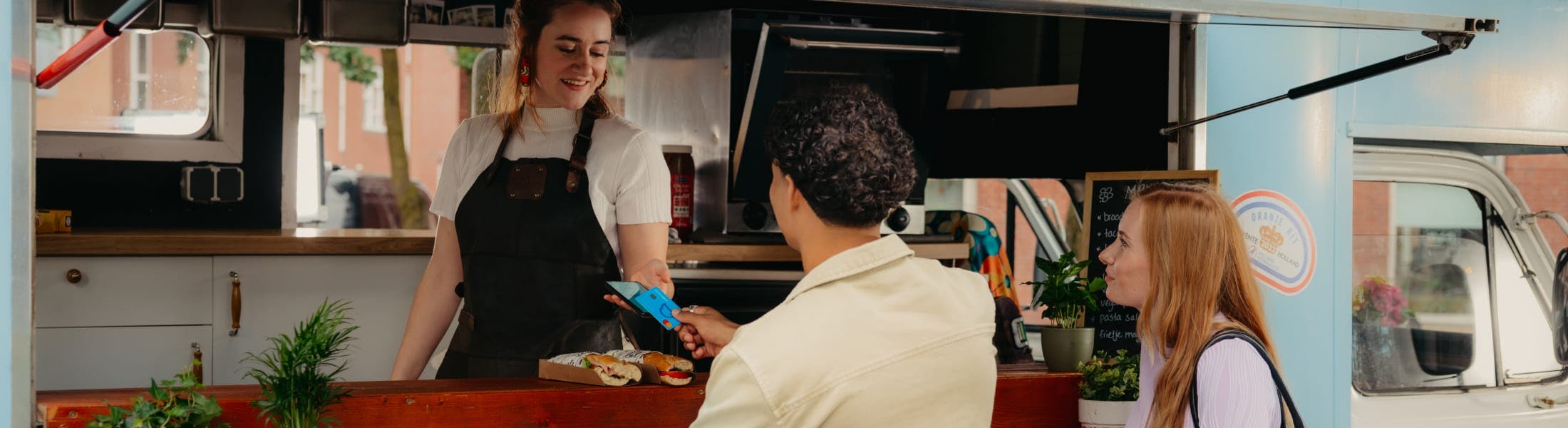 Mees betaald bij een foodtruck met zijn Moneybird bankpas