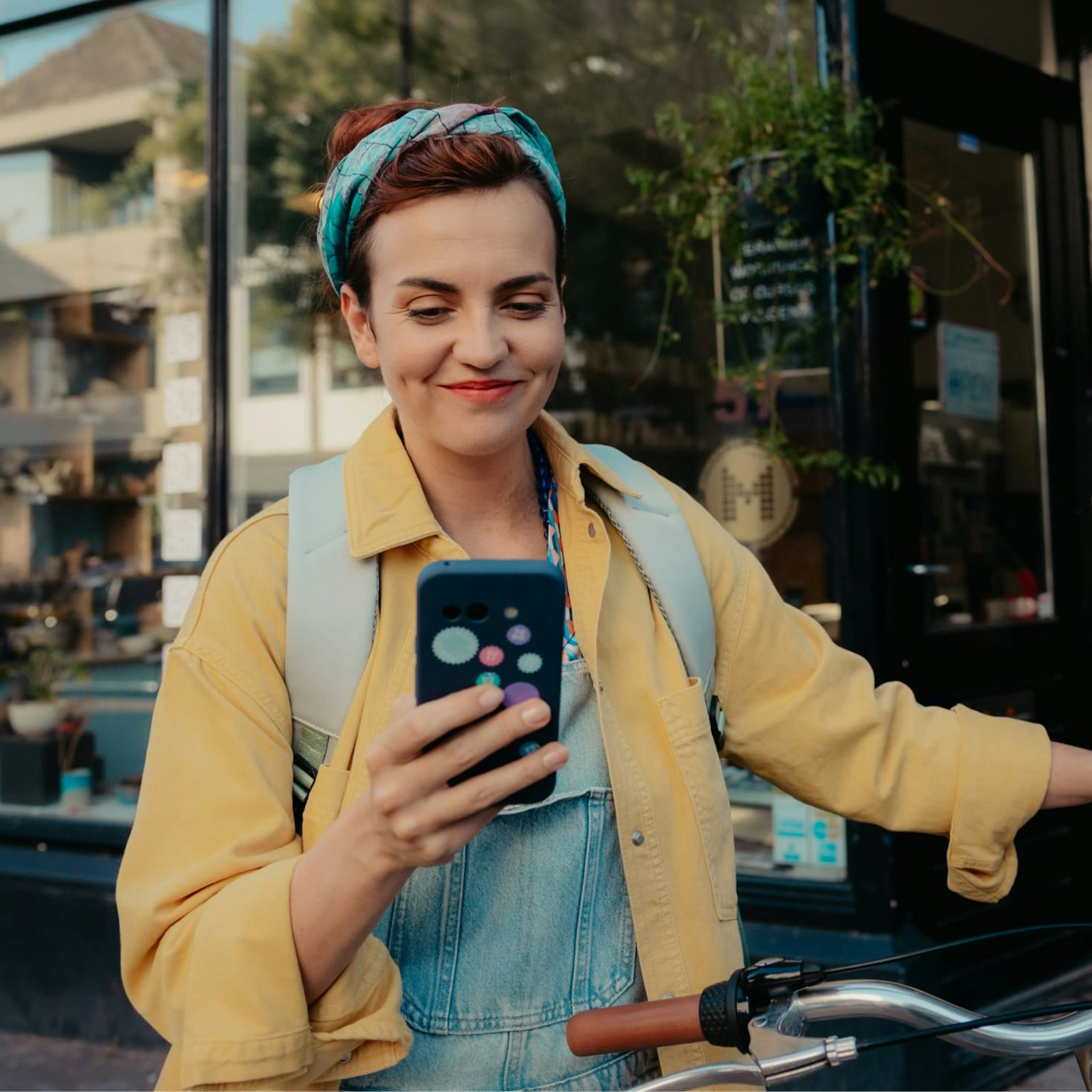 Merel staat met haar telefoon in haar hand bij haar fiet
