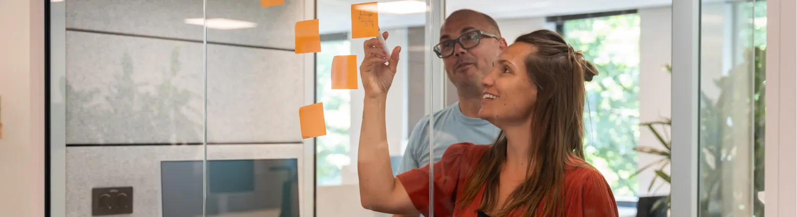 Jeroen en Eva overleggen met post its aan de wand