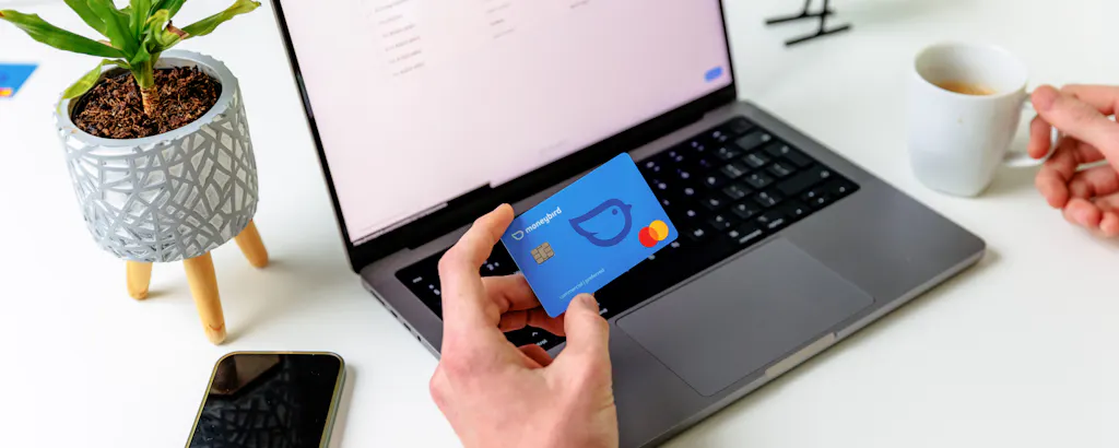 Koffie met mobiele telefoon en betaalpas bij laptop met handen