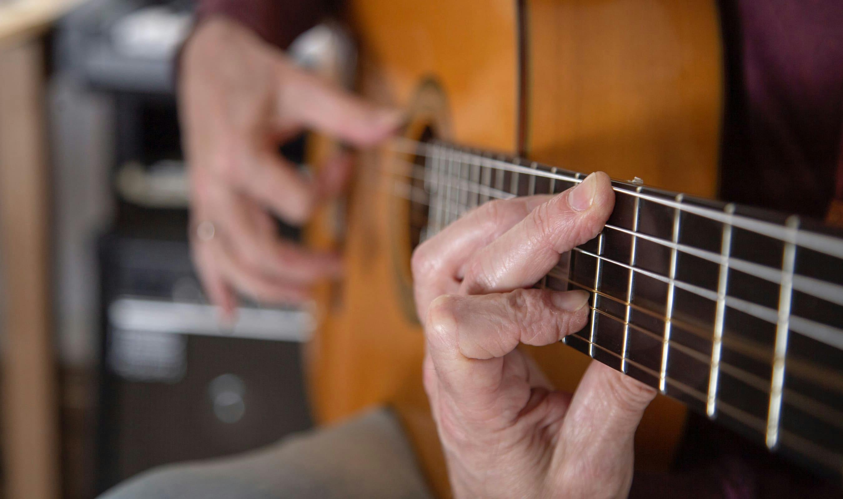 Close-up van handen die gitaar spelen