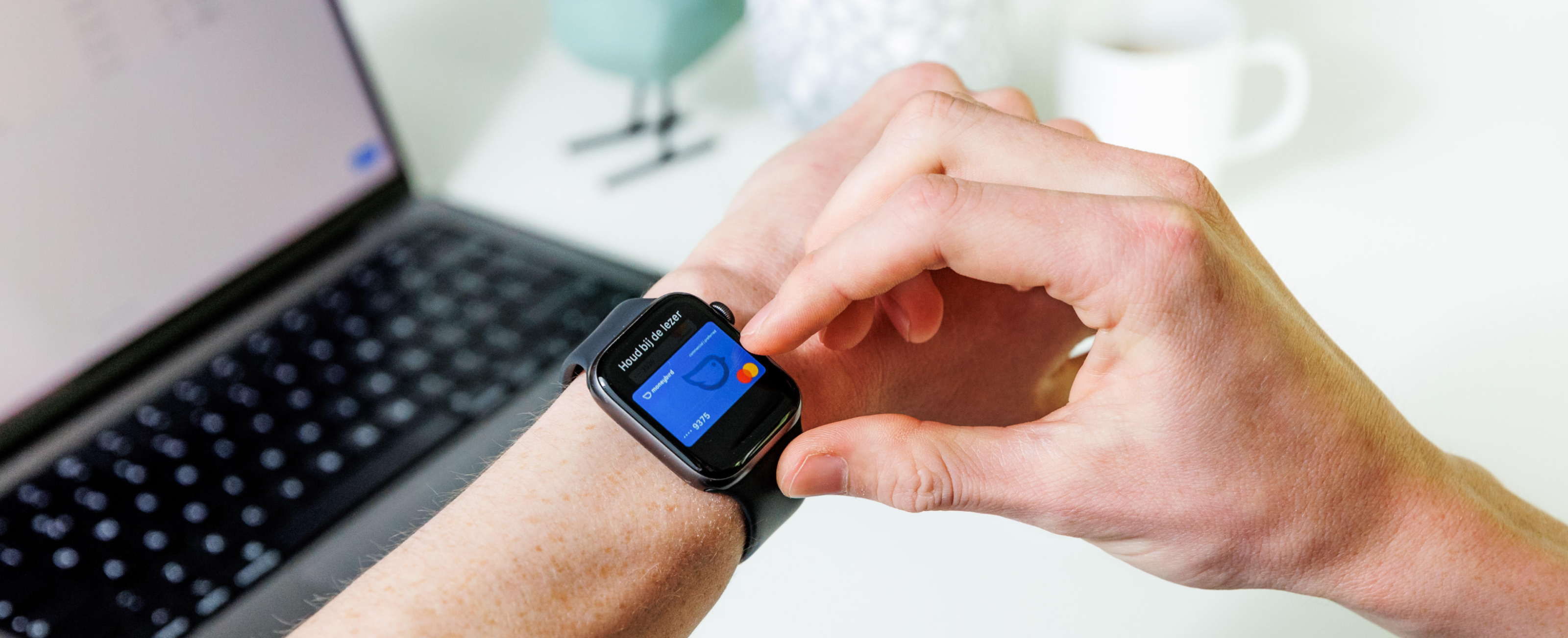 Smartwatch met bankpas bij laptop
