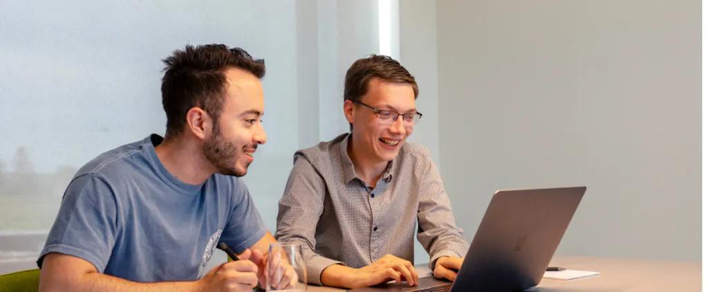 Chiel en een collega samen achter een laptop