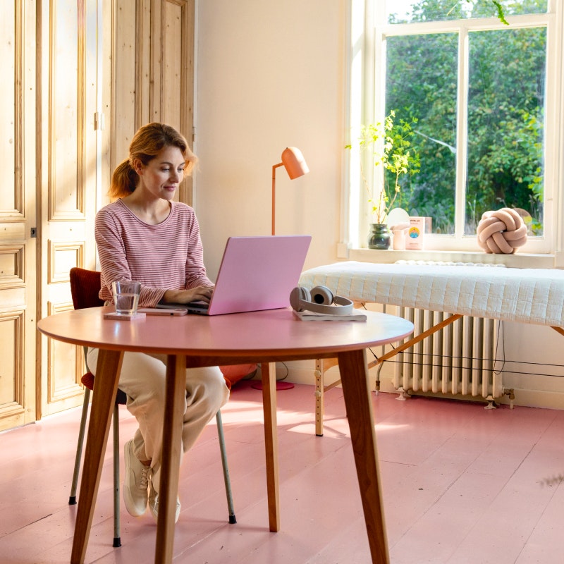 Fysiotherapeut achter laptop terwijl ze aan tafel zit