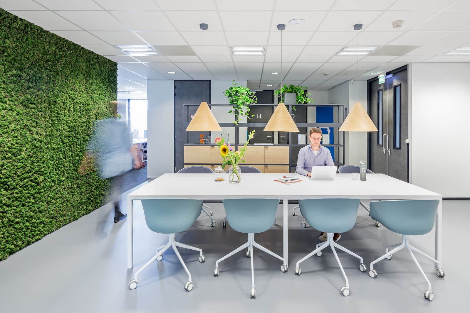 Iemand werkt aan tafel in de huiskamer van het Moneybird kantoor