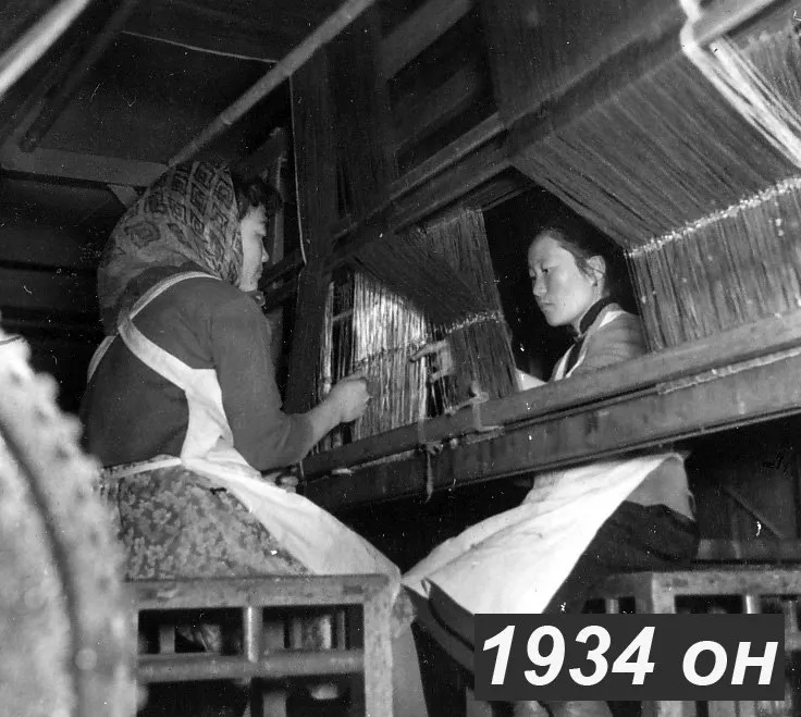 Archive photograph of two employees at a loom.