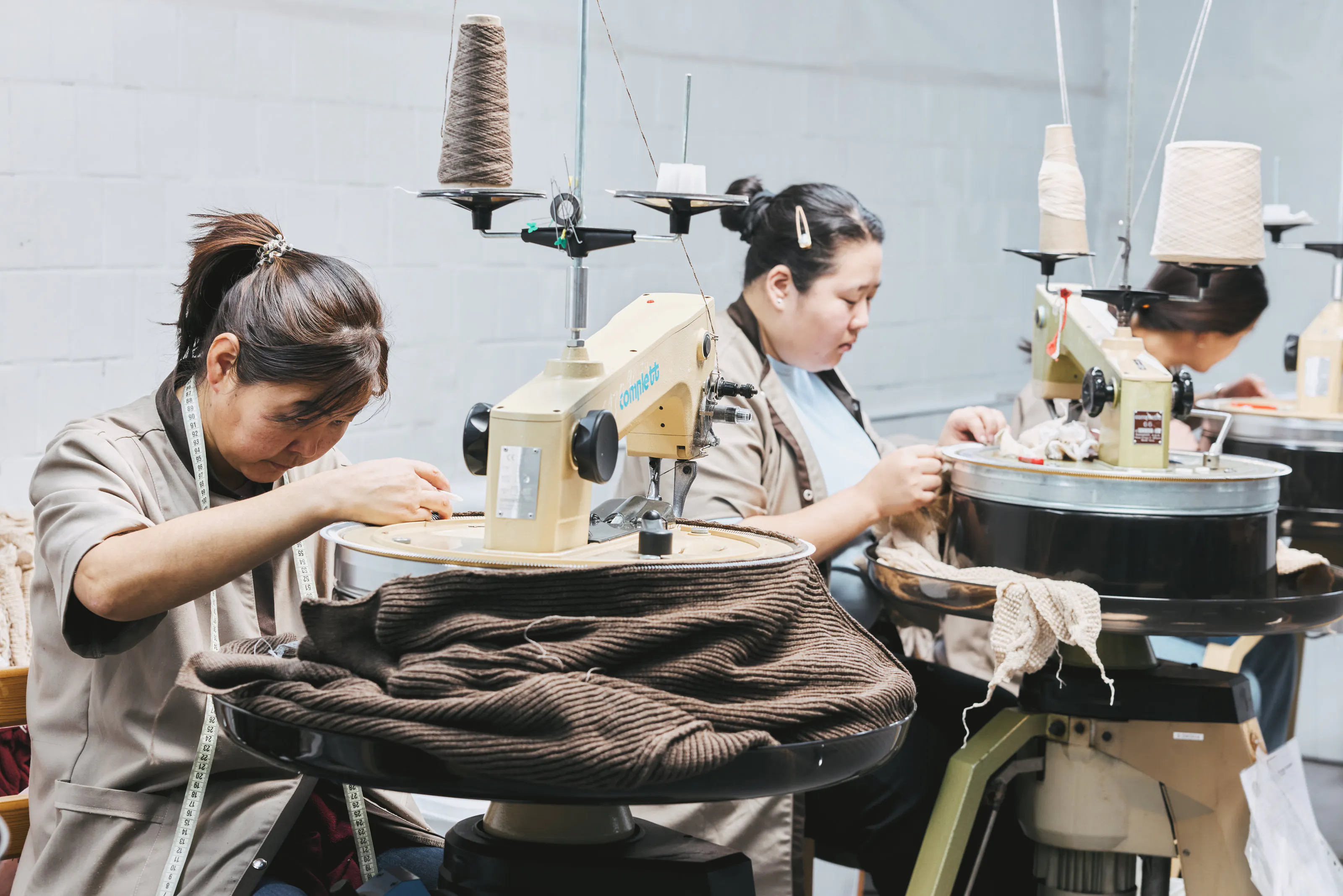 Employees working at circular linking machines.