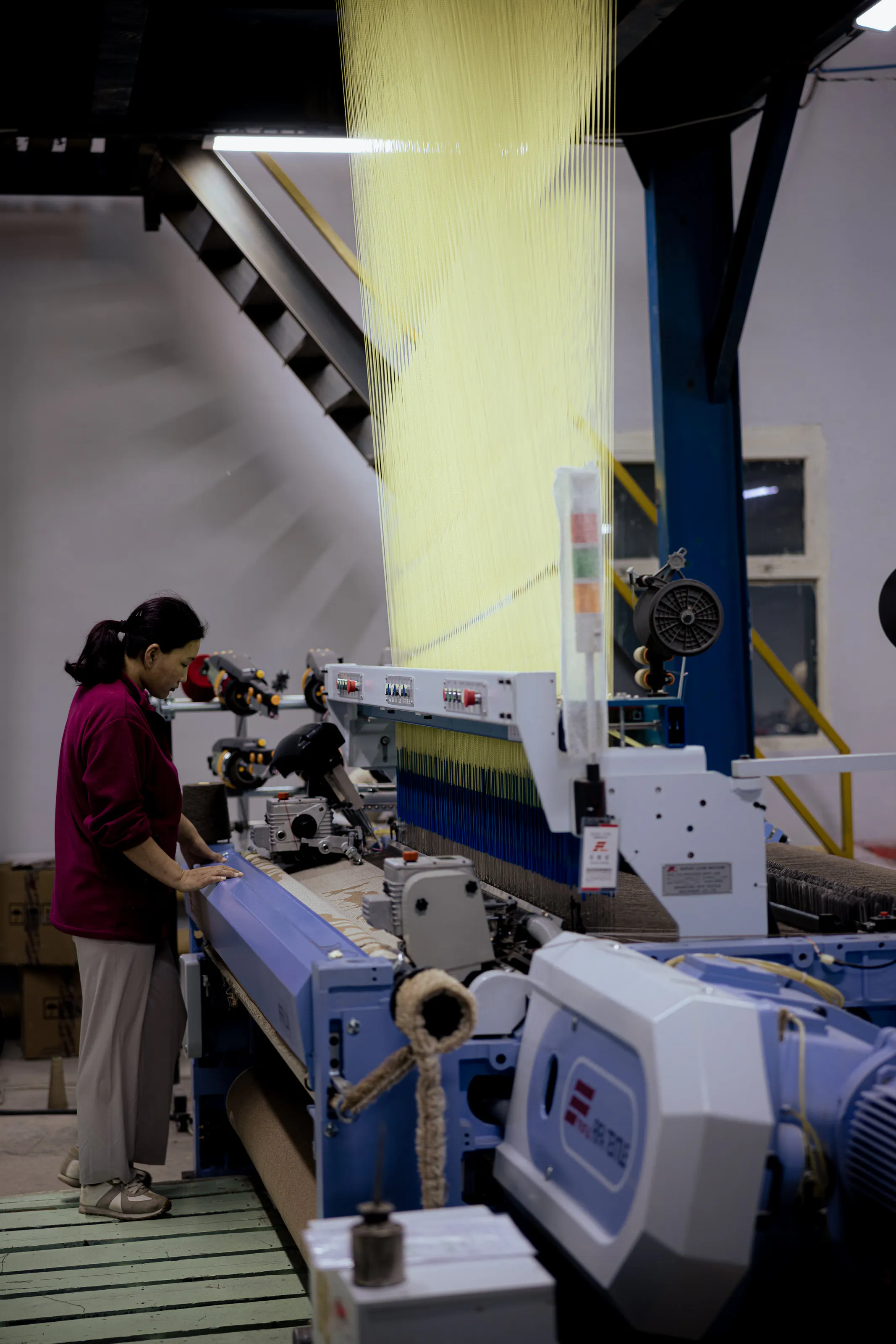 An operator beside a weaving machine.