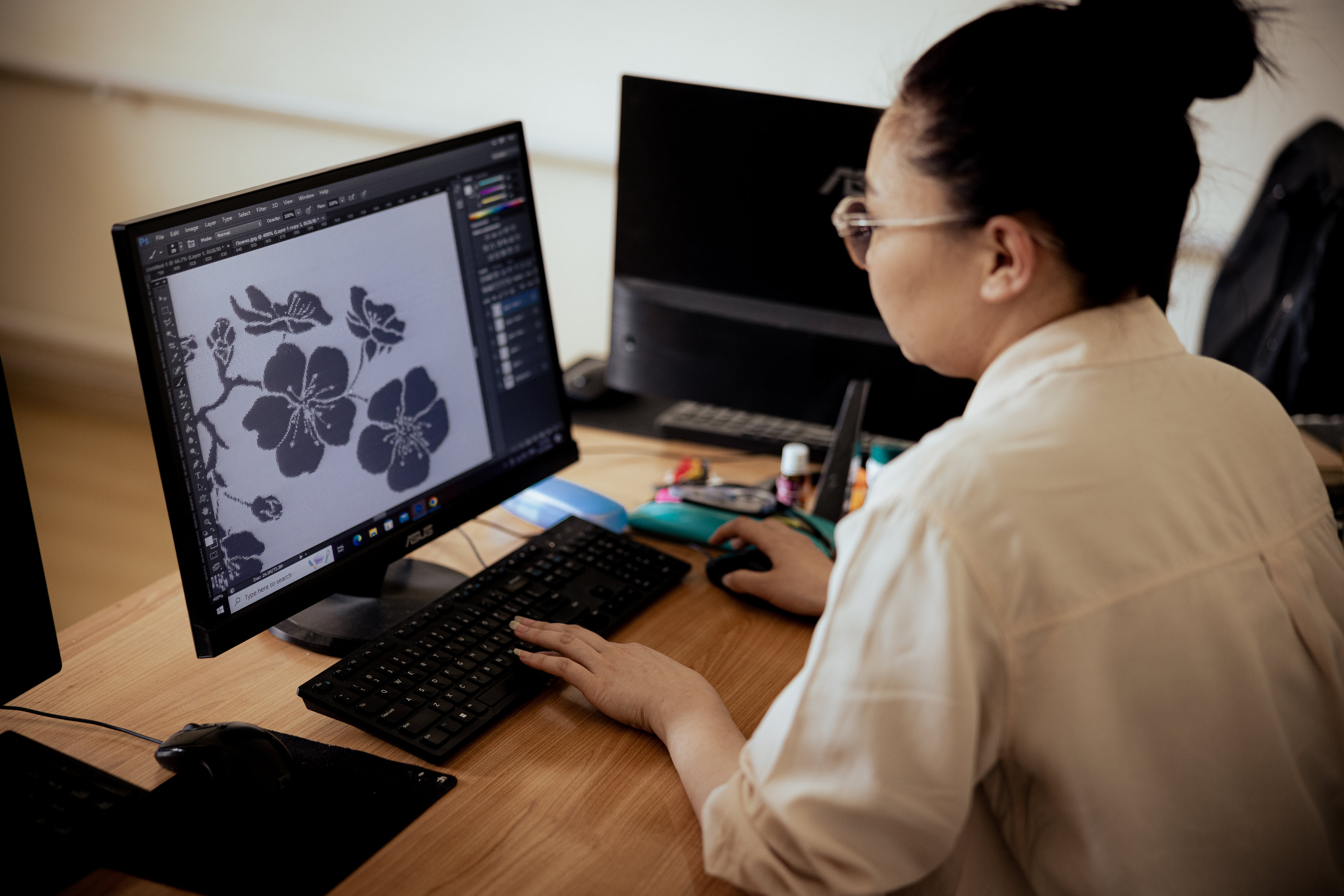 A designer working on a textile motif at a computer.
