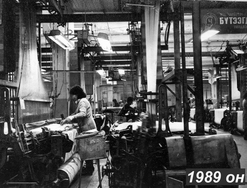 Black-and-white archive photograph of a workroom with textile machinery.