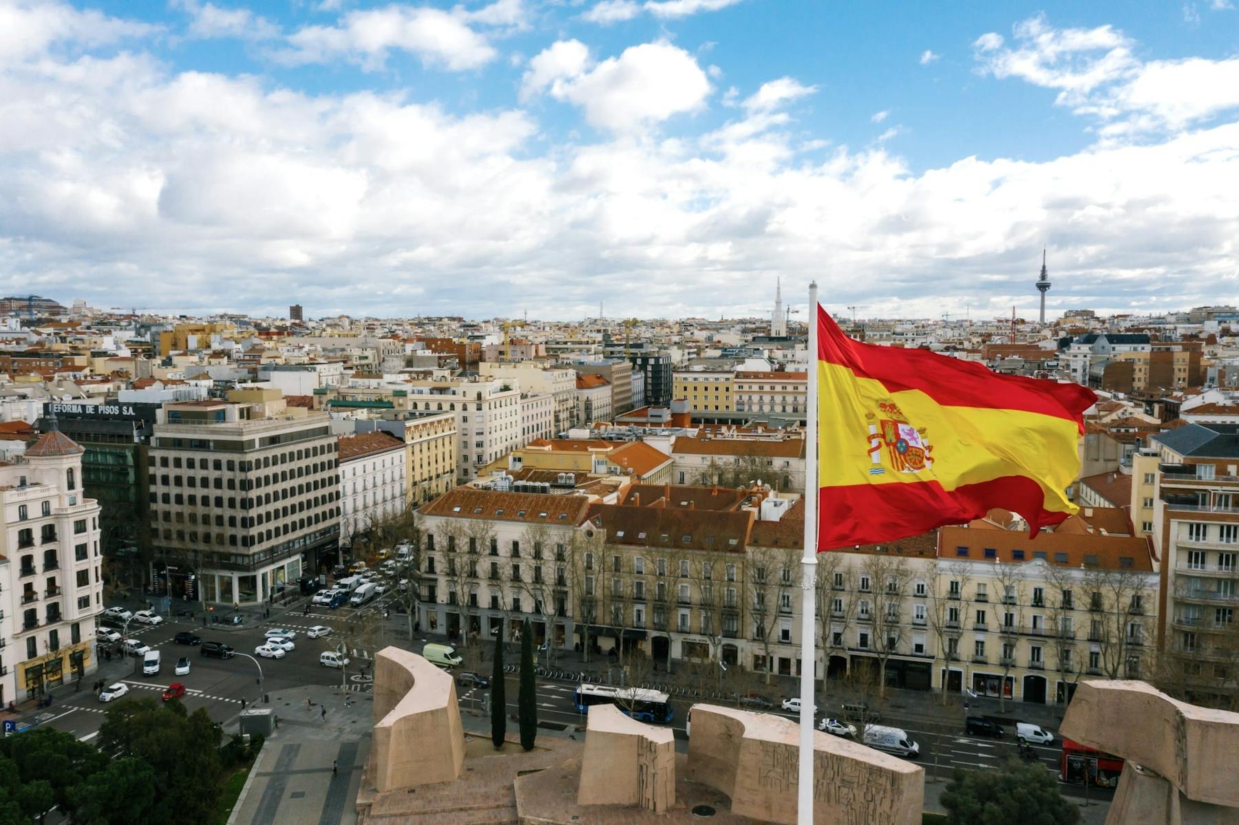 Bandeira da Espanha hasteada com panorama da cidade ao fundo