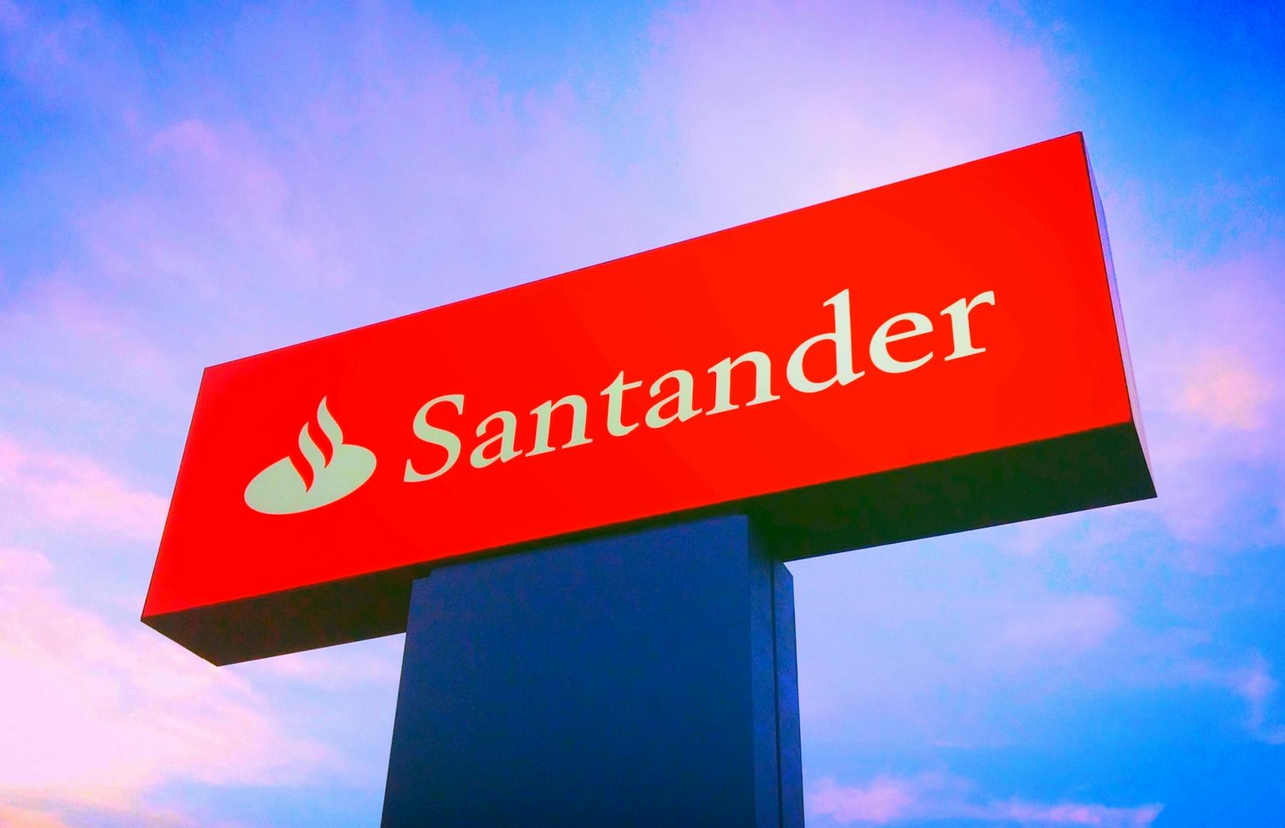 Letreiro do banco Santander com céu ao fundo