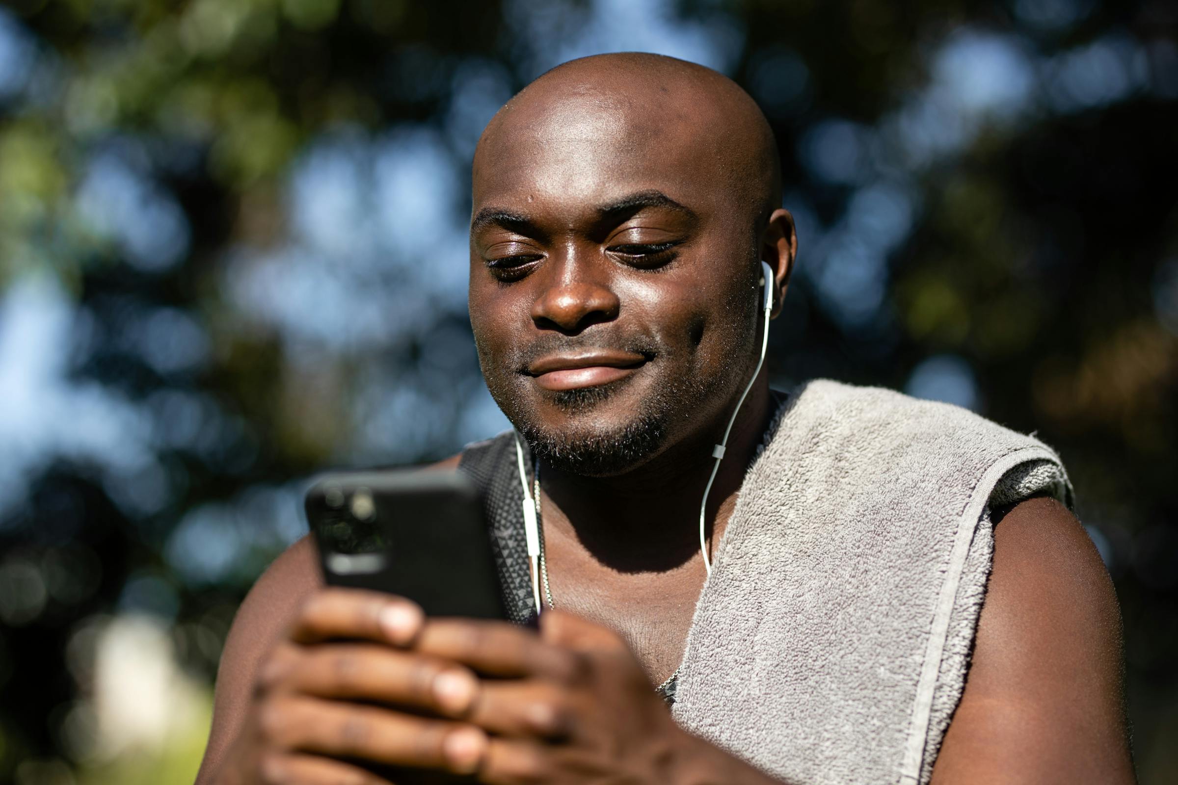 Close-up shot of a man listening to music while using a mobile phone.