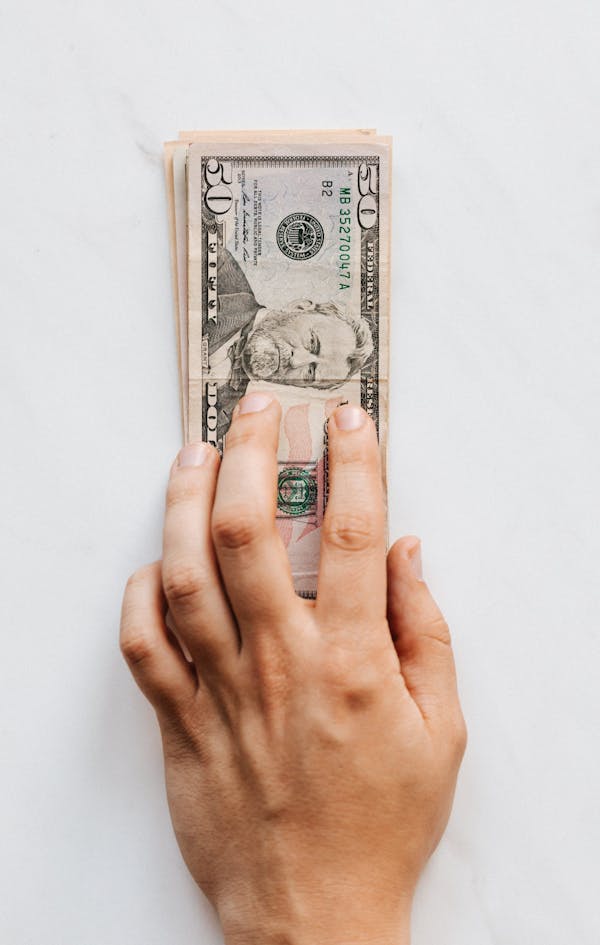 Hand on table with money