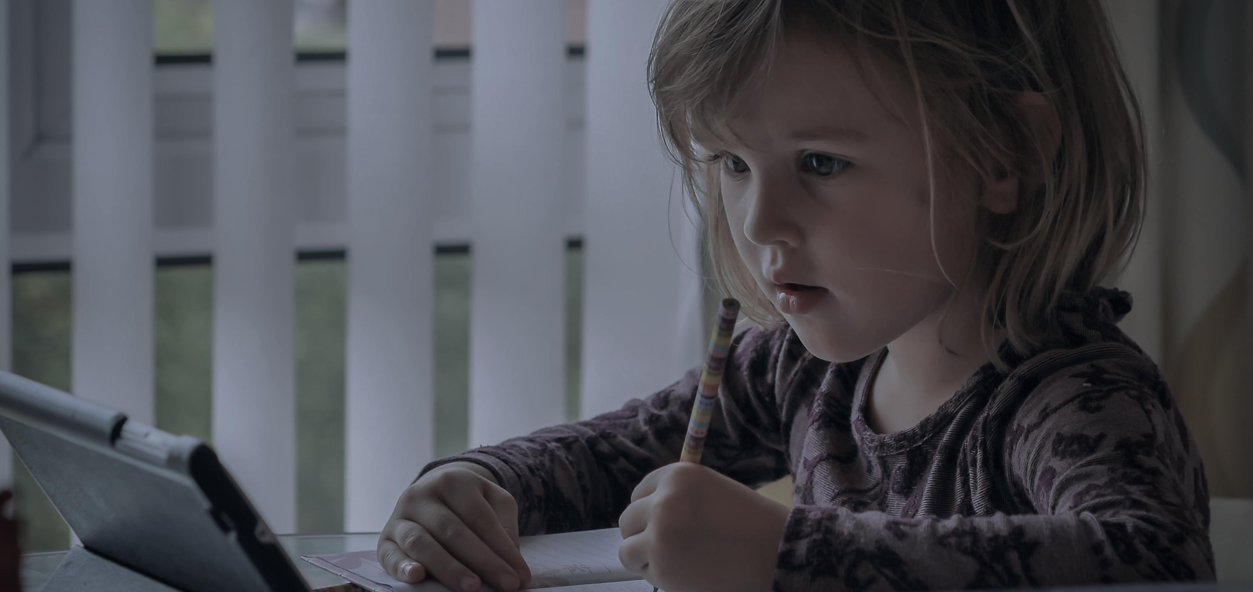 a kid learning on a tablet