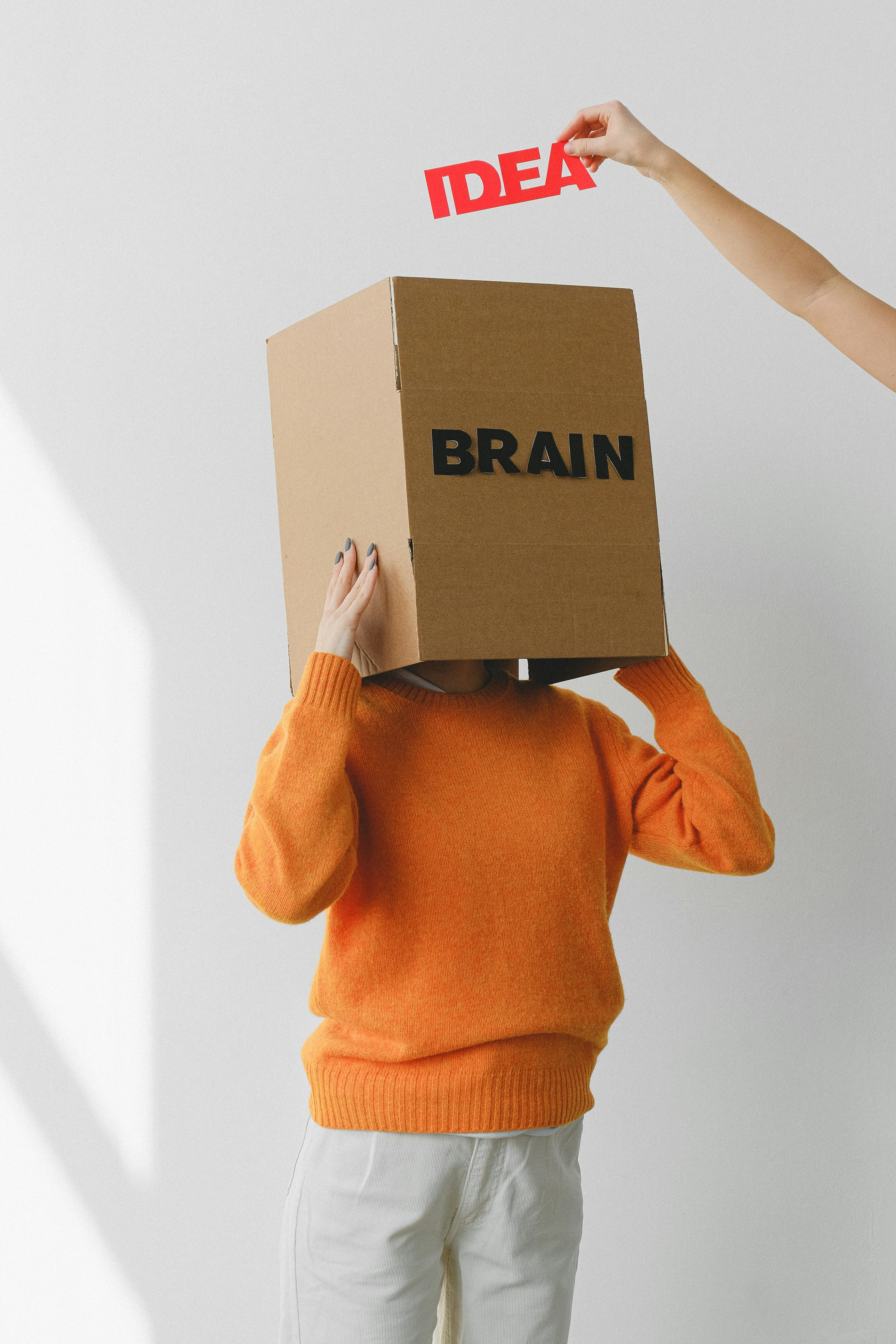 Cardboard upside down with inscription "Brain" and sign "Idea" above it