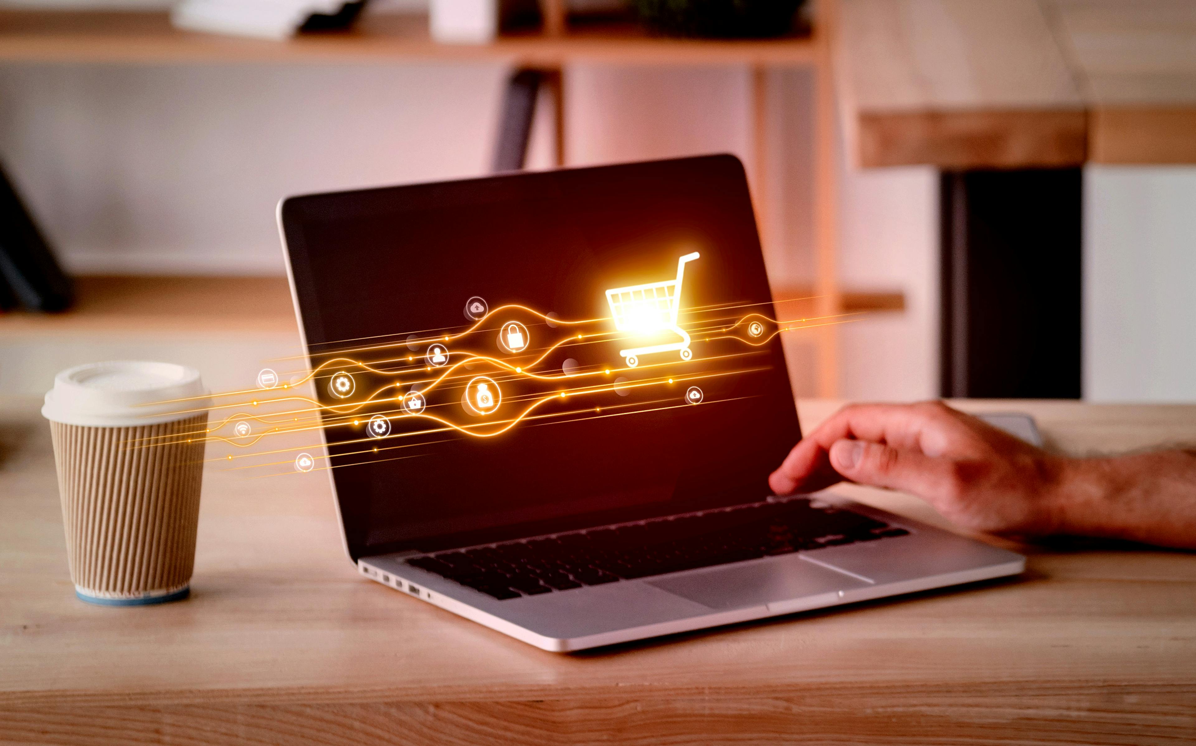 Hand am Laptop mit Onlineshopping Visualisierung