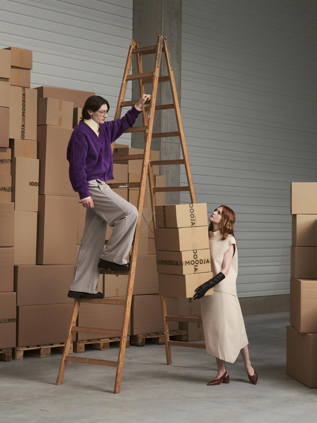 Modells tragen Kartons und klettern Leiter hinauf
